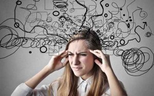 A women who looks very stressed, with multiple scribbles flying out of her head