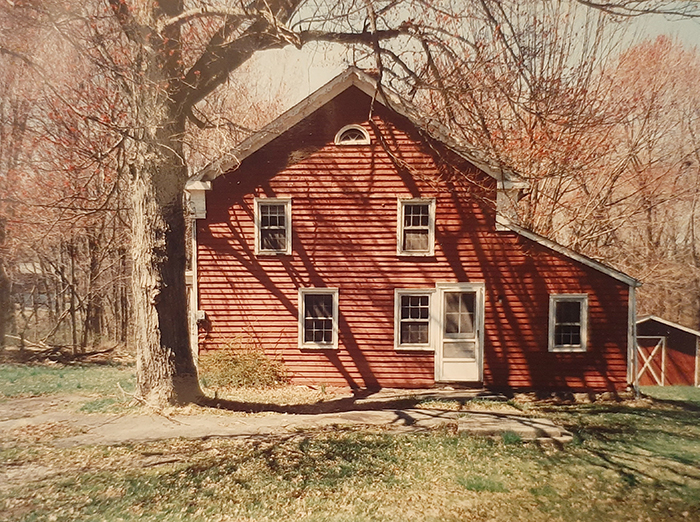 A red barn, with a haze over the photo that gives it an old look